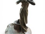 statue of a woman in a dress on a rock with her hands in the air
