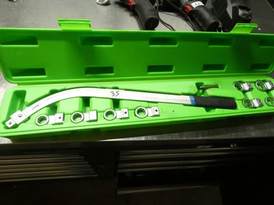 une mallette à outils verte, contenant des outils, posée sur une table