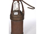 an old fashioned oil canister with a light on top of it