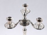 a silver candelab with three candles on it