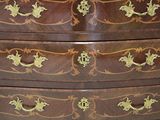 a wooden chest of drawers with gold decorations on it