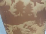 a vase that has a picture of a sky and clouds on it