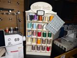 a sewing machine sitting next to a display of spools and thread