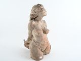 une statue représentant une femme assise sur une surface blanche