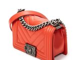 a small red handbag with a chain on a white background