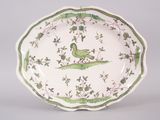 a green and white plate with a bird on it