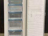 a white refrigerator with its door open on a concrete floor