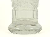 a clear glass vase with a handle on a white surface