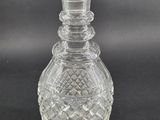 a close up of a clear glass bottle on a black background