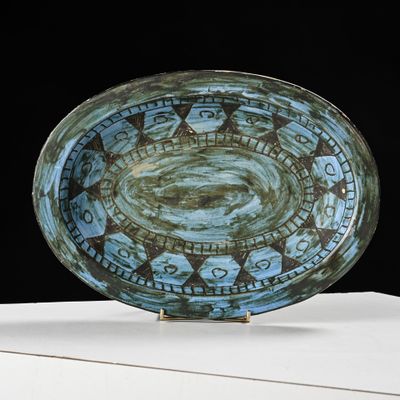a blue plate with a design on it sitting on a table