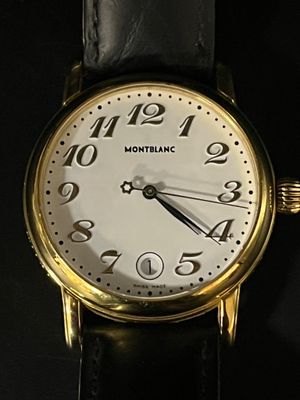 gros plan d'une montre-bracelet en or sur une surface noire