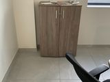 une chaise noire dans un coin de la pièce, à côté d'une armoire
