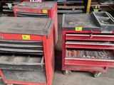 two red tool carts with tools on top of them in a warehouse