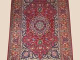 a red and blue rug with a medallion design on it
