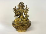 a gold statue of a buddha sitting on top of a bowl