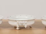 three white bowls sitting on top of a wooden table next to each other