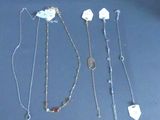 several necklaces and bracelets are arranged in a row on a table