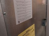a metal box with a sign on it next to a door