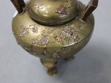 a brass tea pot with a lid on a table