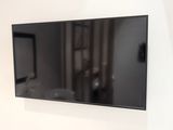 un téléviseur à écran plat accroché au mur d'une pièce