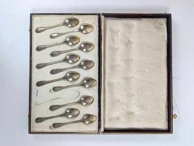 six cuillères dans une boîte posée sur une surface blanche