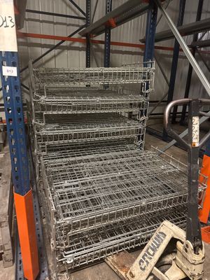 une pile d'étagères métalliques dans un entrepôt, sur laquelle est accrochée une pancarte