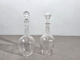 deux bouteilles en verre transparent posées l'une à côté de l'autre sur une table