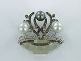 une broche en perles et diamants sur fond blanc