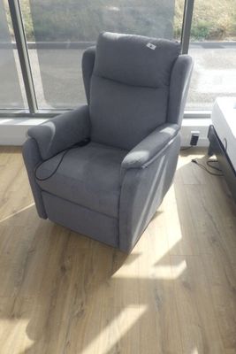 un fauteuil inclinable dans un coin de la pièce, à côté d'un lit