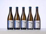 six bottles of white wine lined up on a table