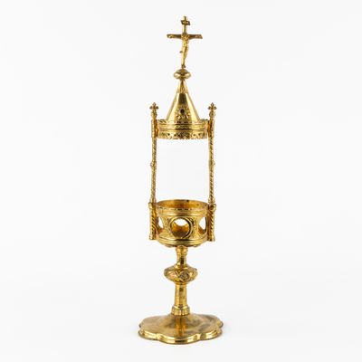 an image of a gold cup with a cross on top of it