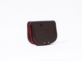 Le petit sac à main noir et rouge est posé sur une surface blanche.