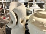two white vases sitting on a table in a room