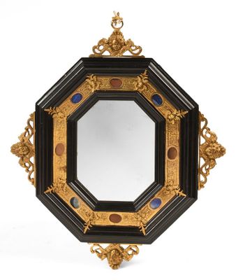 un miroir ouvragé doté d'un cadre noir et de finitions dorées