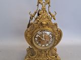 une horloge en or posée sur une table blanche
