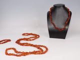 une photo montrant un collier et un bracelet posés sur un présentoir pour mannequin