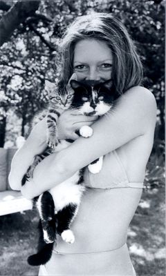 photographie en noir et blanc d'une femme en bikini tenant un chat dans ses bras