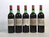 four bottles of wine are lined up on a table