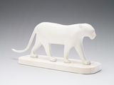 a white sculpture of a cat on a wooden base