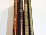 three old books are stacked on top of each other on a table