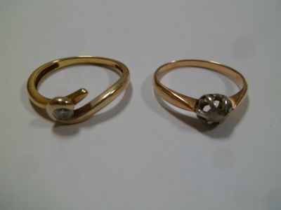 paire de bagues en or ornées de diamants sur une surface blanche