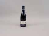 une bouteille de vin posée sur une table blanche