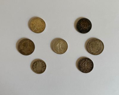cinq types de pièces différents sur une surface blanche