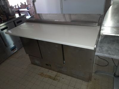 plan de travail en acier inoxydable dans une cuisine professionnelle équipée d'un lave-vaisselle