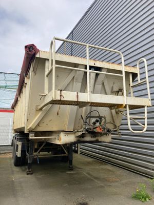 une photo d'un camion-benne garé devant un immeuble