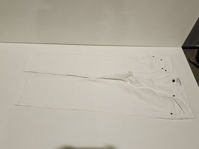 a piece of white paper on the floor next to a pair of scissors