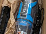 a blue and black vacuum in a box on the floor