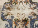 a rug on the floor with a chair in the background