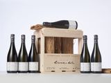 six bottles of wine in a wooden crate with a cork