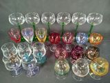 many different colored wine glasses lined up on a table